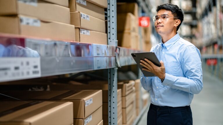 Warehouse worker reviewing inventory on a tablet